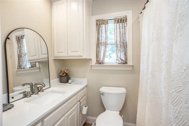 a bathroom with a toilet a sink and a window