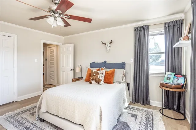a bedroom with a balcony a bed and dresser with wooden floor