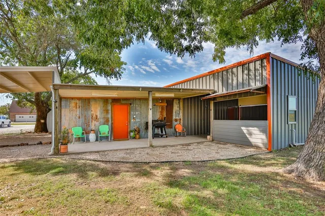 a view of a house with a patio and a yard