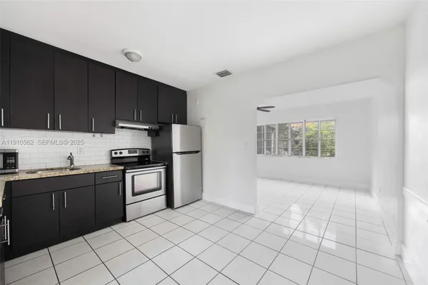 a kitchen with stainless steel appliances granite countertop a refrigerator sink and cabinets
