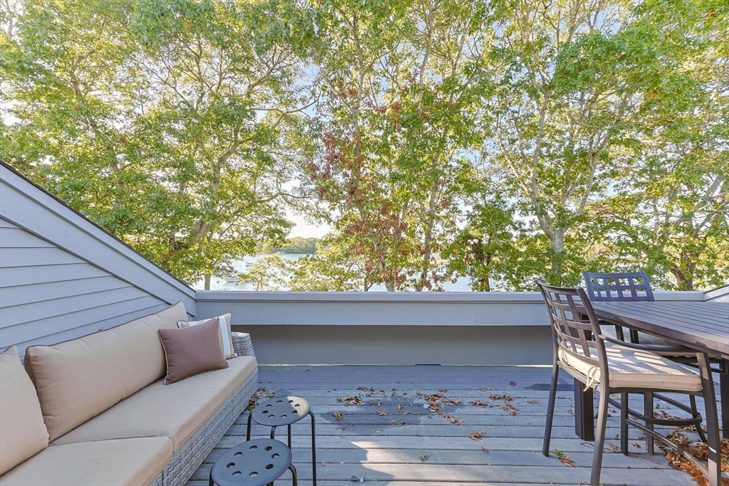 381 Great Oak Road, Unit 9 Mashpee, MA 02649 - Photo 30 of 42 a backyard of a house with table and chairs