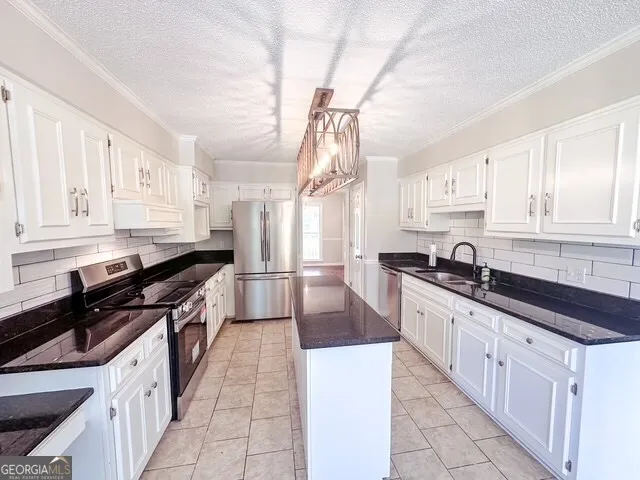 a kitchen with stainless steel appliances a sink stove cabinets and a window