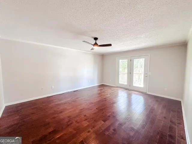 an empty room with wooden floor and windows