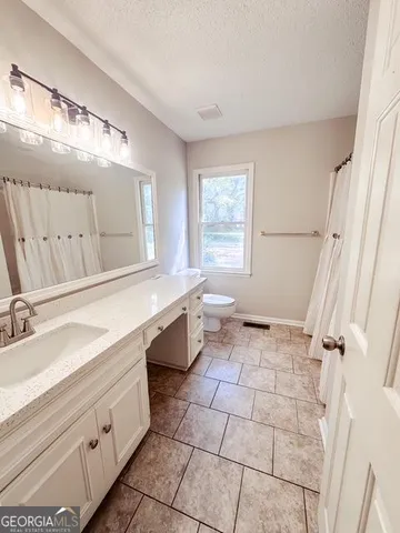 a bath room with a toilet a bath tub and a window