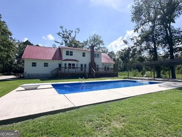 a view of house with yard and swimming pool