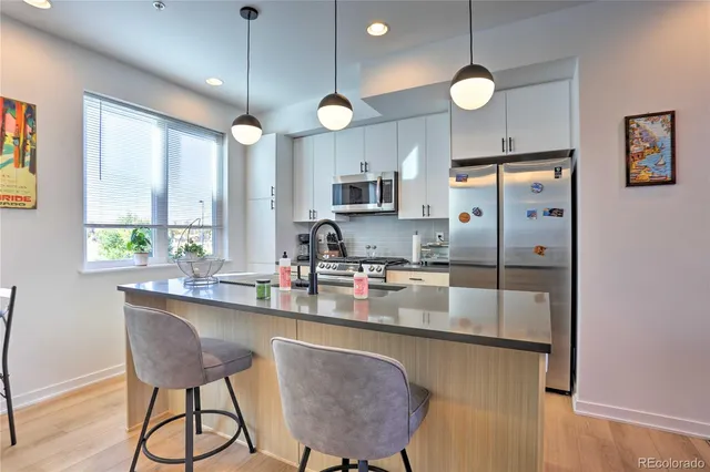 a kitchen with stainless steel appliances granite countertop a stove a sink and a refrigerator