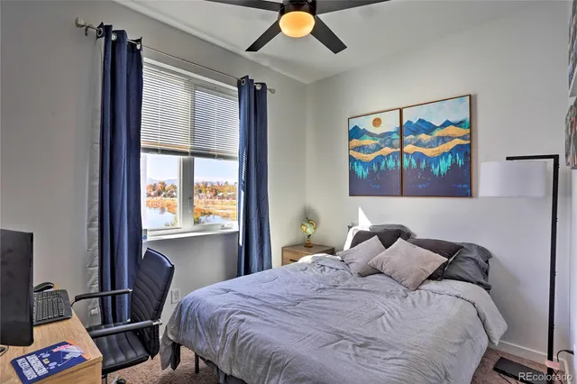 a bedroom with a bed and a painting on the wall