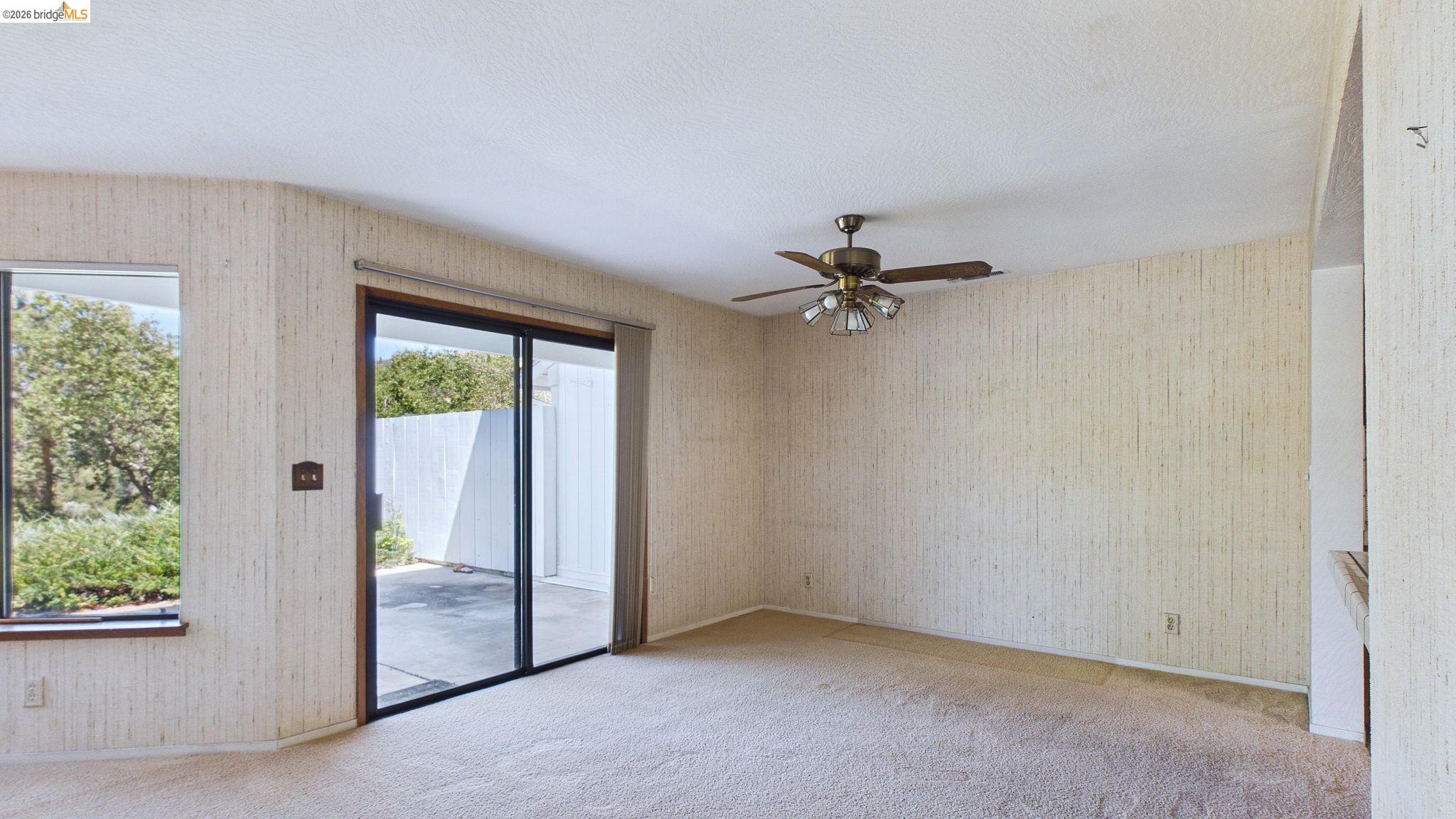 23686 Marble Quarry Road, Unit 72 Columbia, CA 95310 - Photo 13 of 35 Carpeted interior with textured wall coverings, featuring a ceiling fan with integrated lighting