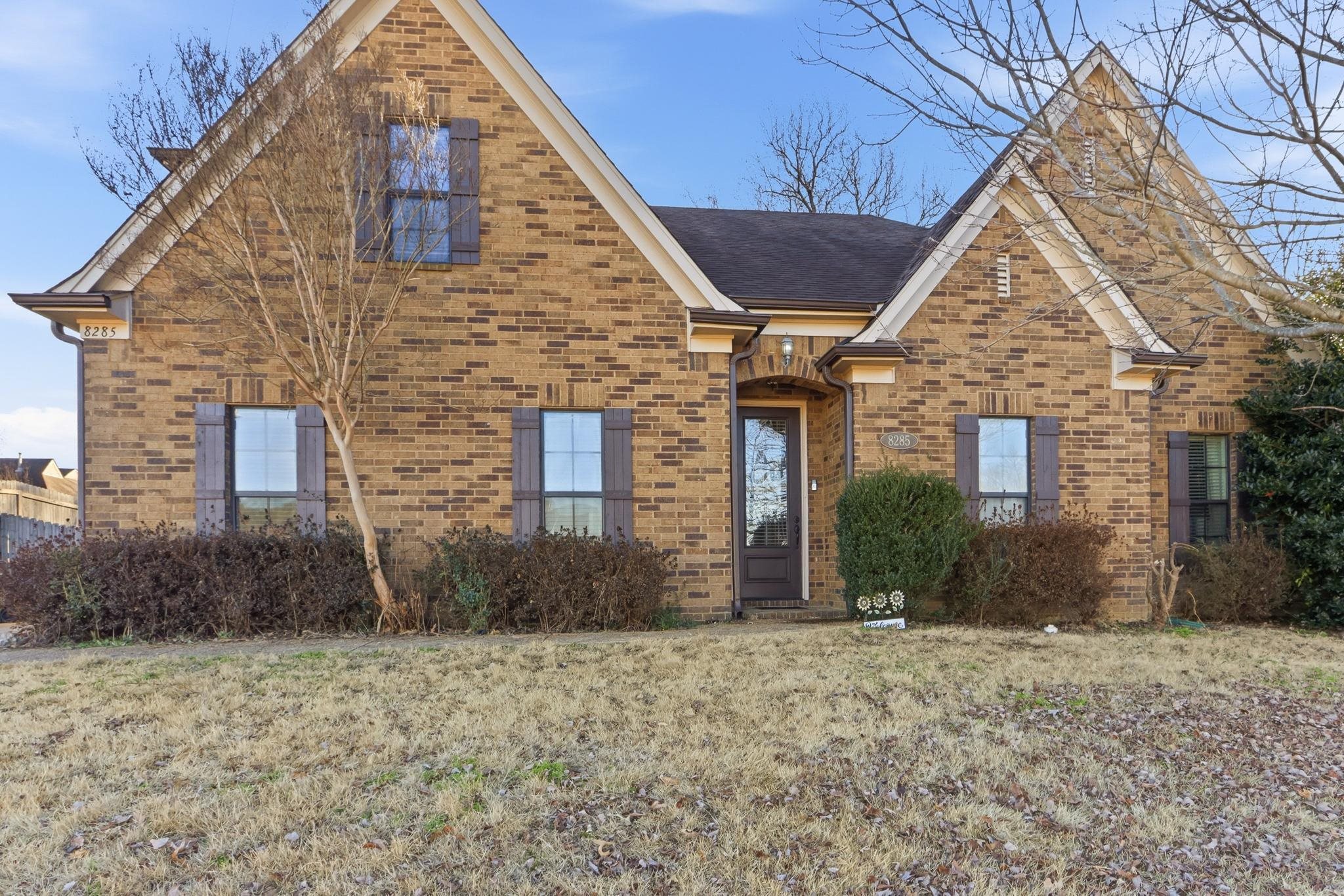 a view of a brick house with large windows