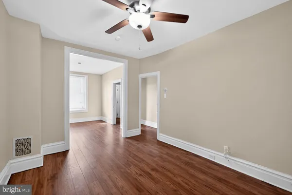 a view of an empty room with wooden floor