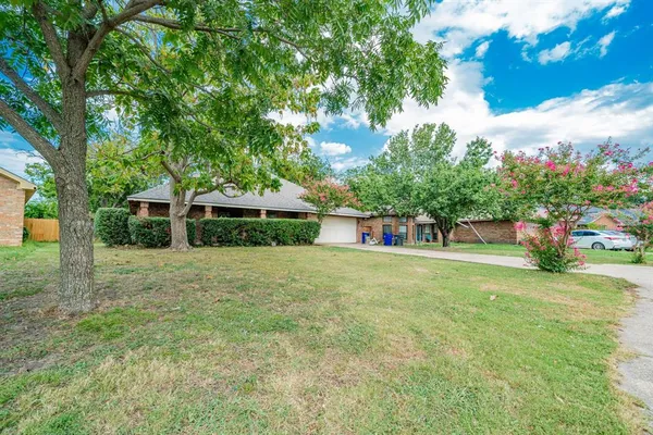 a front view of a house with a yard and trees
