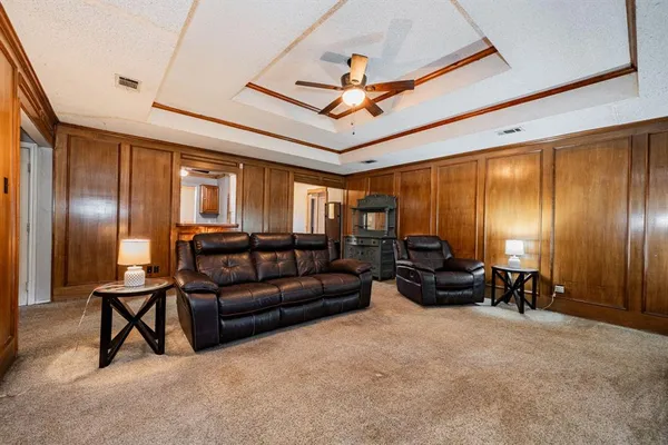 a living room with furniture ceiling fan and a wooden floor