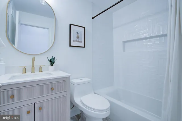 a bathroom with a toilet a sink a mirror and vanity