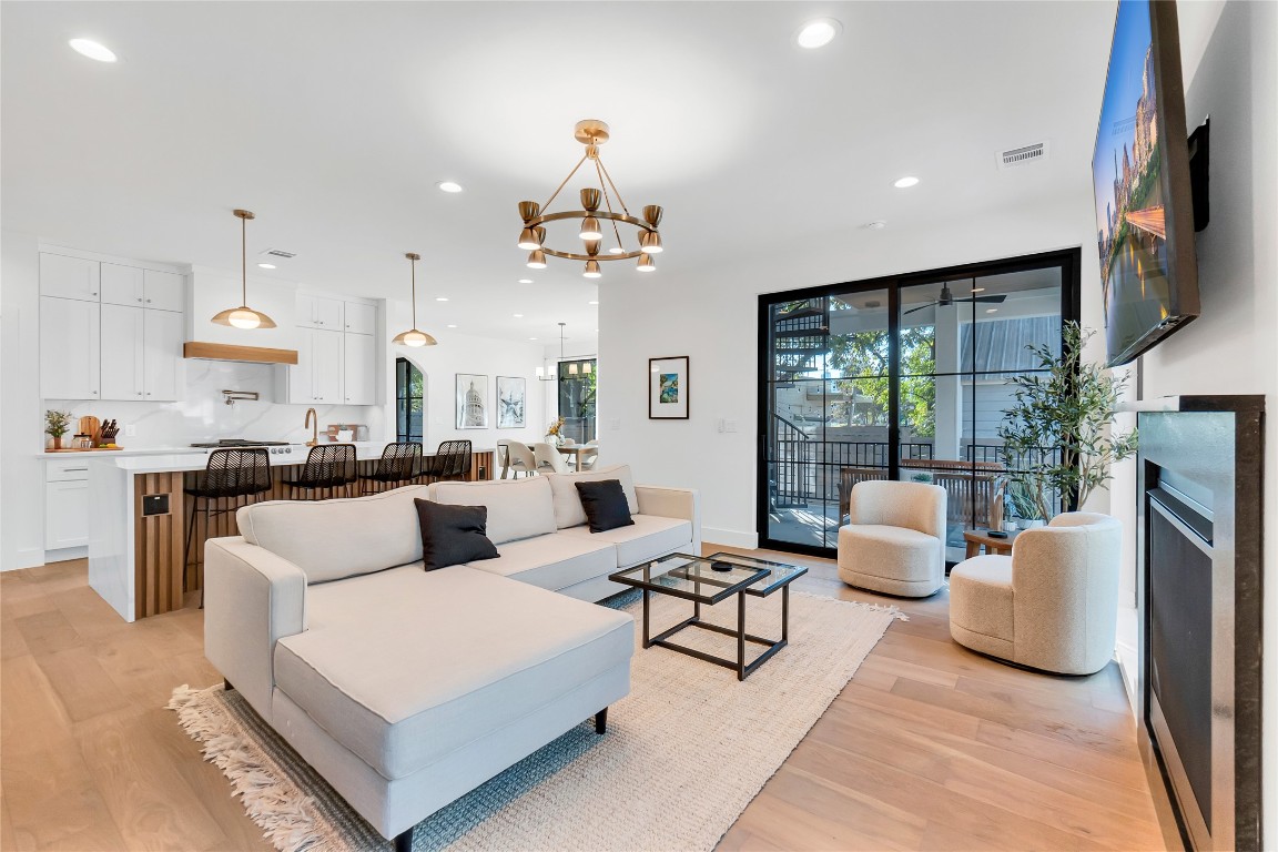 1902 Tillotson Avenue Austin, TX 78702 - Photo 12 of 40 Living room with a chandelier, recessed lighting, light wood-style floors, and a fireplace