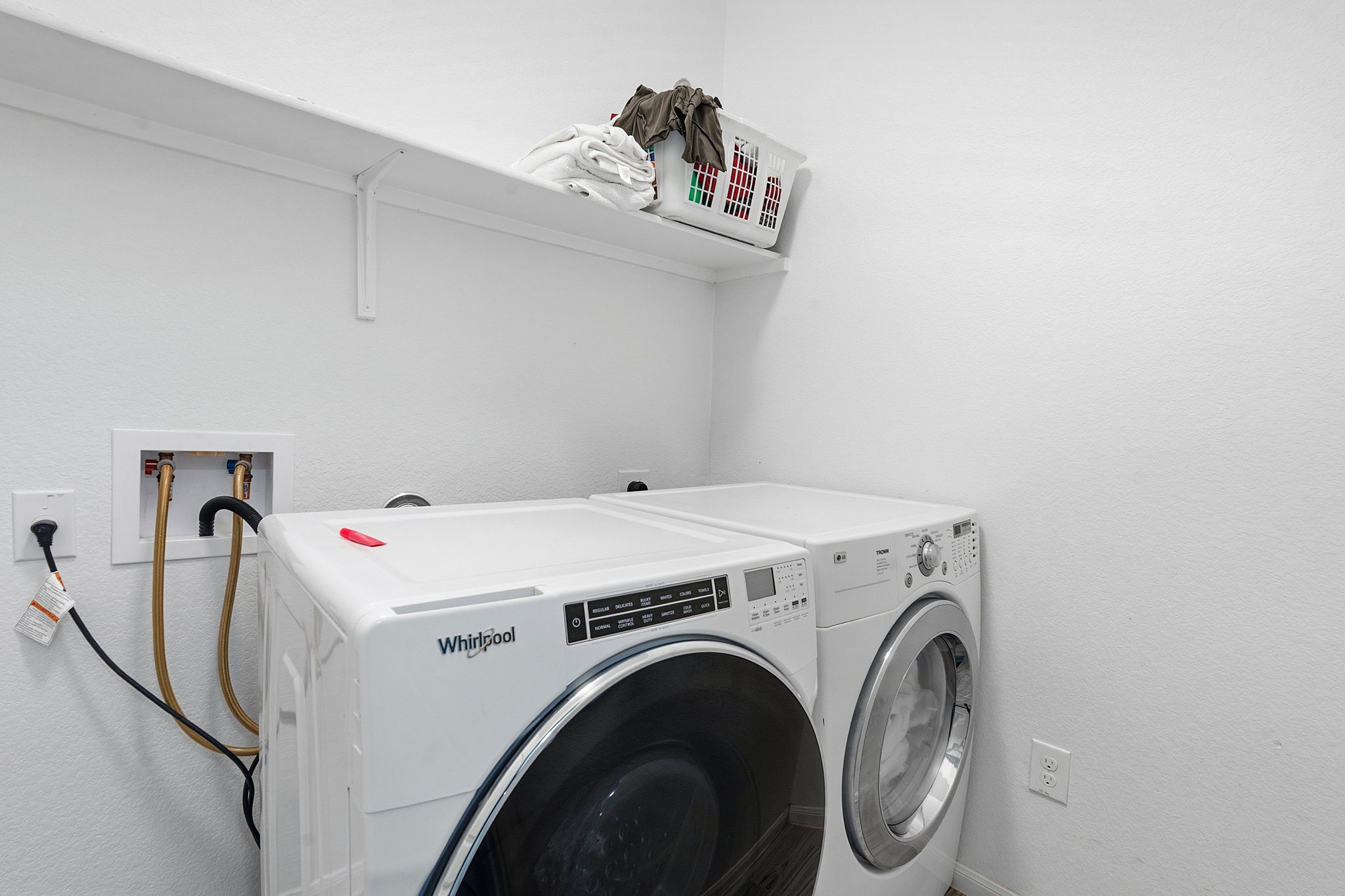 15101 Shell Bark Cove Austin, TX 78724 - Photo 23 of 26 Dedicated laundry area featuring a white floating shelf, white textured walls, and integrated plumbing connections