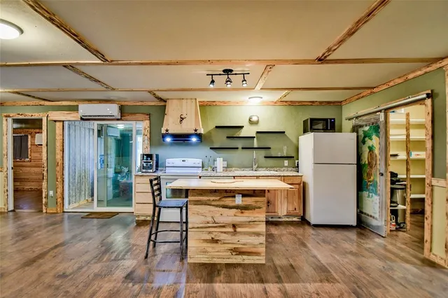 a kitchen that has a lot of white cabinets and stainless steel appliances