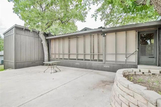 a view of a backyard with table and chairs and a large tree