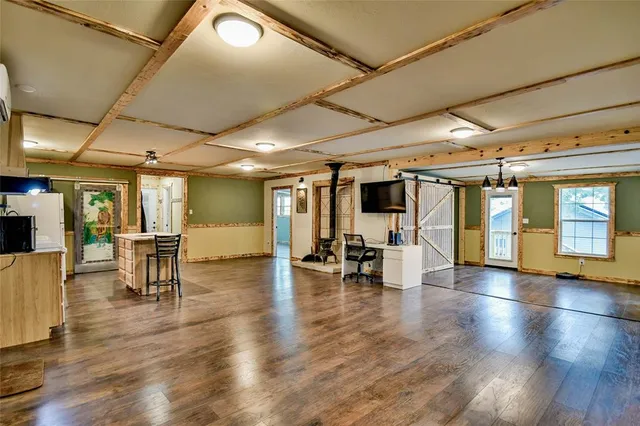 a living room with couches and kitchen view with wooden floor