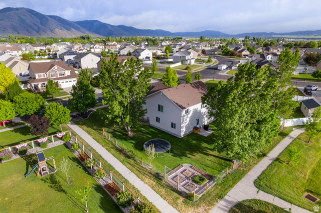 2485 South 1100th Street West Logan, UT 84321 - Photo 44 of 53 Corner lot property featuring a spacious grass yard, mature trees, and raised garden beds