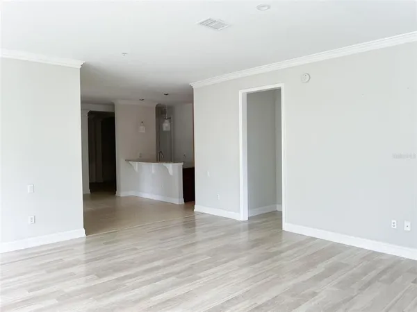 a view of an empty room with wooden floor
