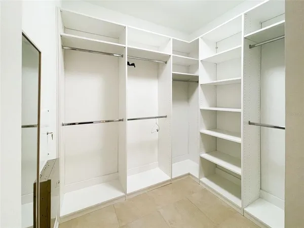 a view of walk in closet with empty racks