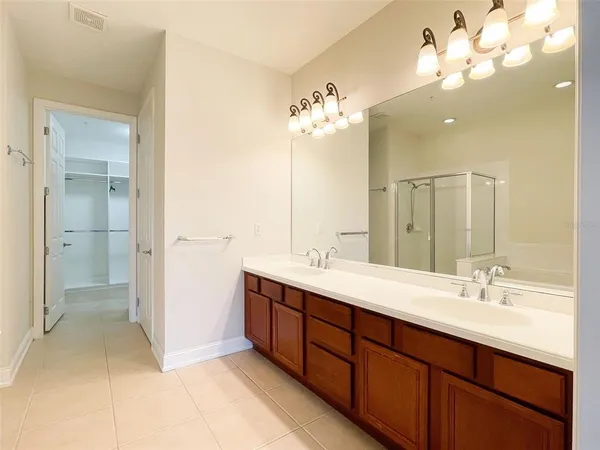 a spacious bathroom with a double vanity sink a mirror and a shower