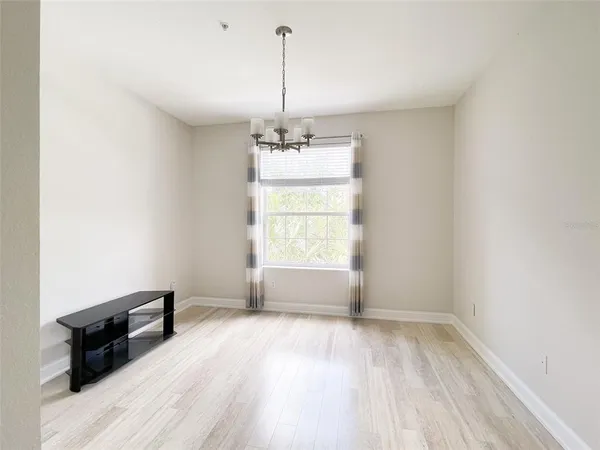 a view of a room with wooden floor air conditioner and a window
