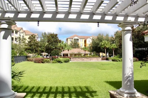 a view of a swimming pool with a patio and plants