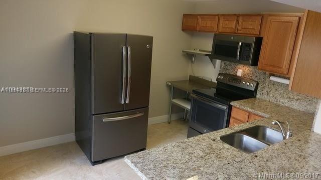 4708 Southwest 67th Avenue, Unit L23 Miami, FL 33155 - Photo 2 of 19 a kitchen with stainless steel appliances granite countertop a refrigerator and a sink