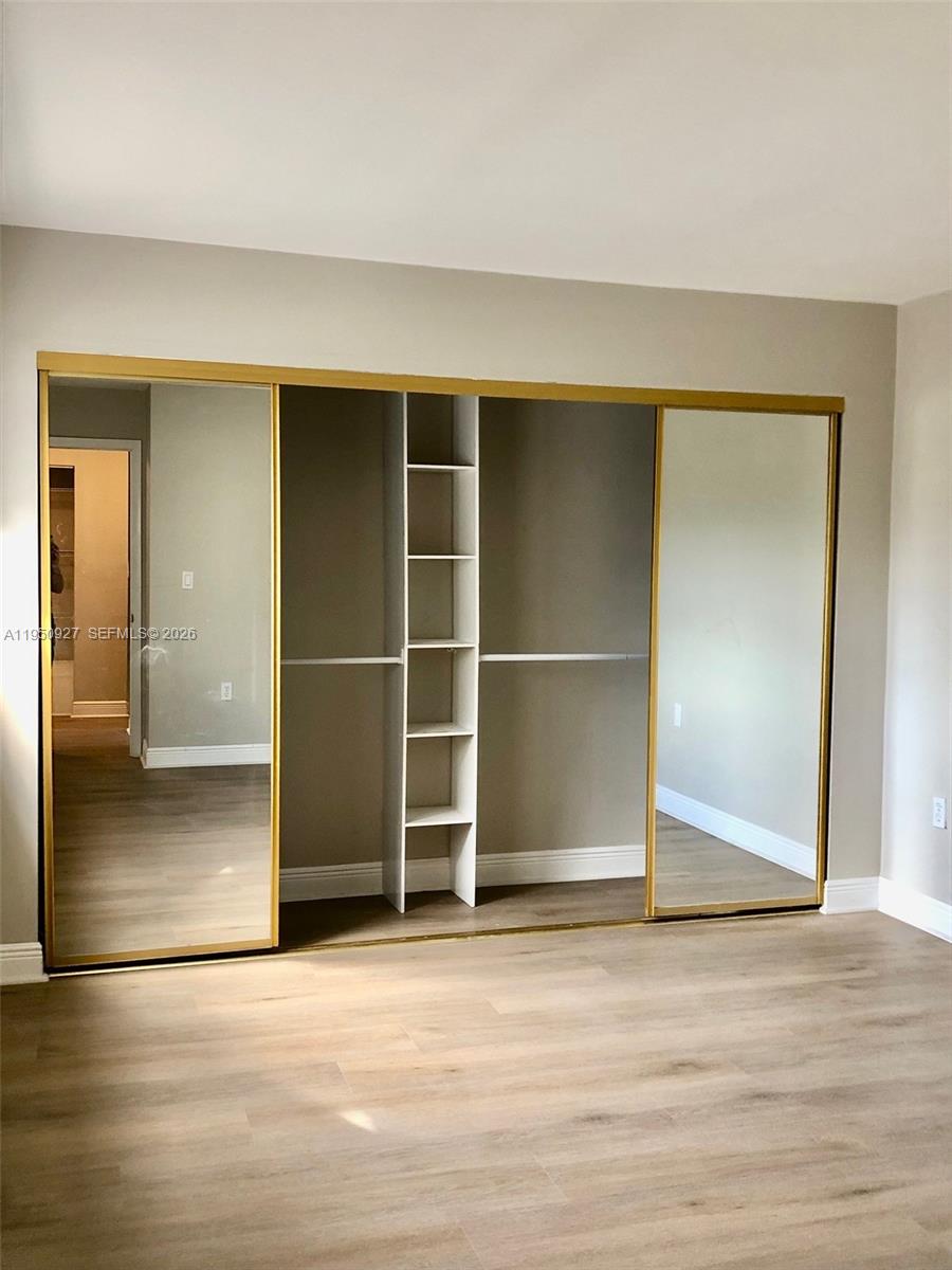 4708 Southwest 67th Avenue, Unit L23 Miami, FL 33155 - Photo 8 of 19 an empty room with wooden floor and windows