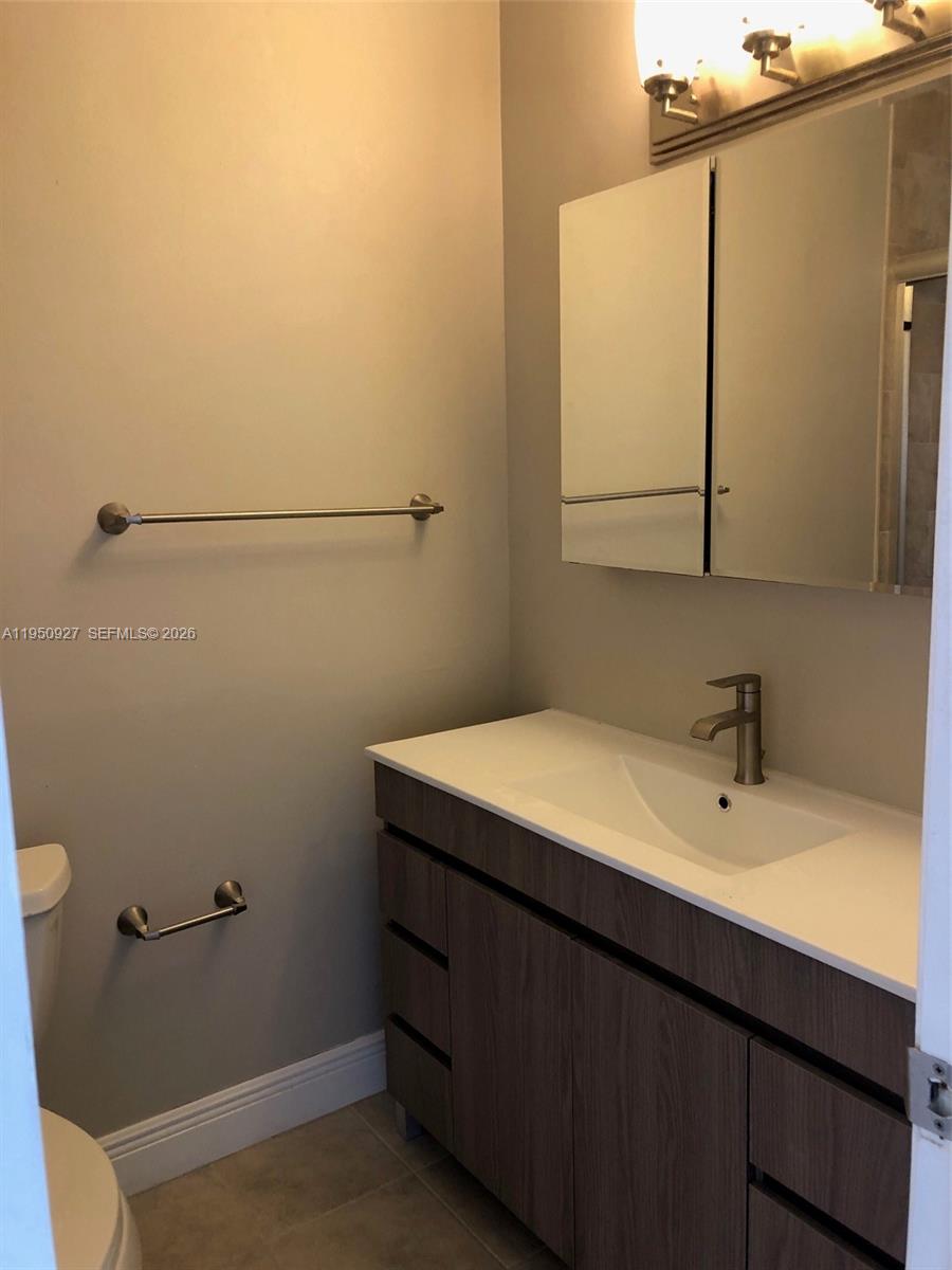 4708 Southwest 67th Avenue, Unit L23 Miami, FL 33155 - Photo 9 of 19 a bathroom with a sink a mirror and a toilet