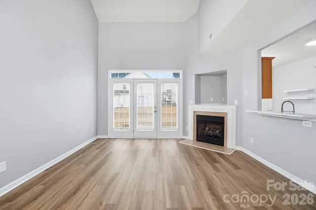 a view of an empty room with a fireplace and a window