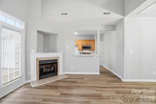 a view of a livingroom with a fireplace and wooden floor