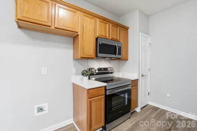 a kitchen with stainless steel appliances granite countertop a stove microwave and sink