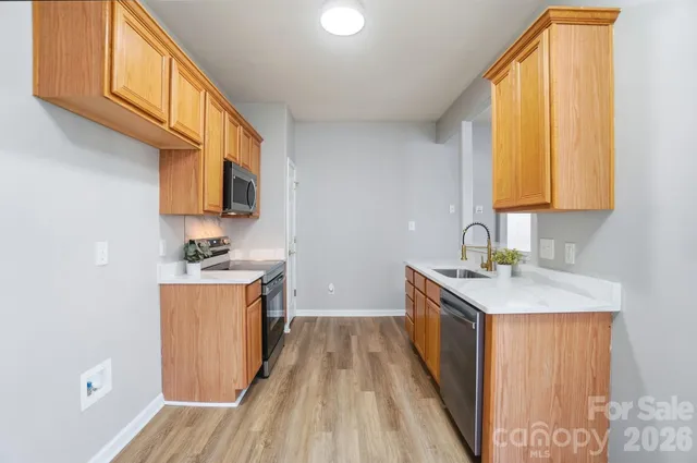 a kitchen with stainless steel appliances granite countertop a sink and wooden cabinets