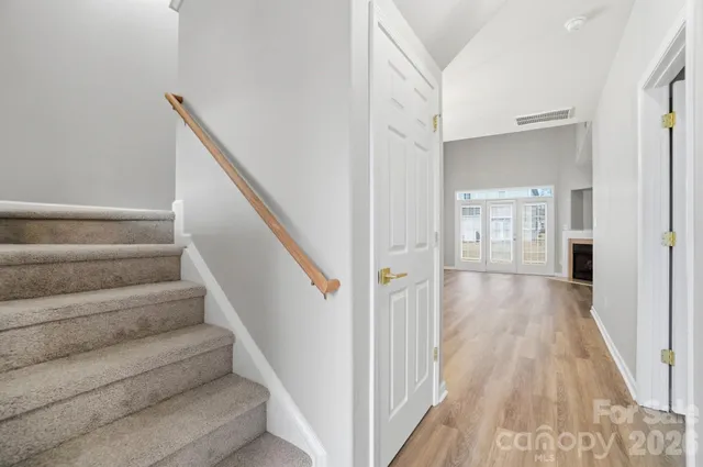 a view of a hallway with wooden floor and staircase
