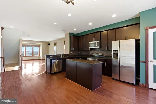 a kitchen with stainless steel appliances granite countertop a stove a sink and a microwave
