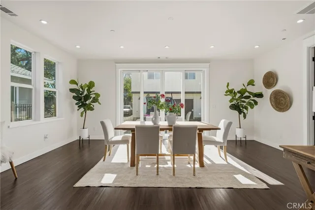 a dining room with furniture potted plants and wooden floor