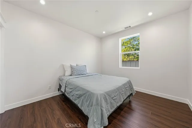 a bedroom with a bed and wooden floor