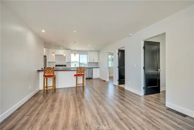 a kitchen with stainless steel appliances wooden floor and chair
