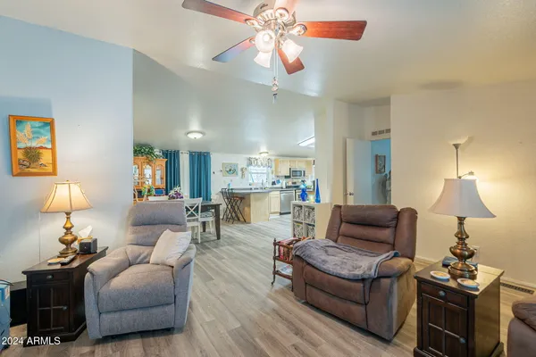 a living room with furniture a chandelier and a lamp
