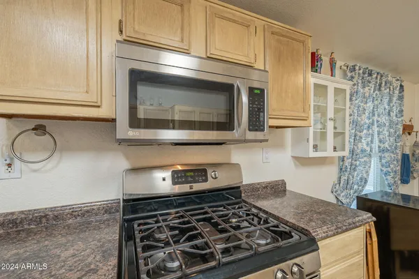 a kitchen with granite countertop a stove and a microwave