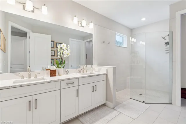 a bathroom with a double vanity sink mirror and shower