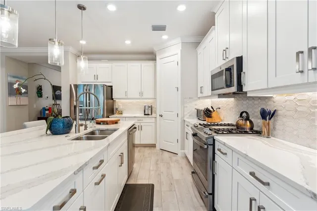 a kitchen with stainless steel appliances granite countertop a sink stove and refrigerator
