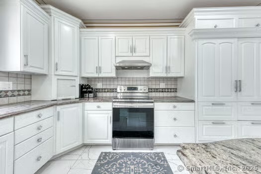 93 South Road Farmington, CT 06032 - Photo 17 of 40 a kitchen with granite countertop white cabinets and stainless steel appliances