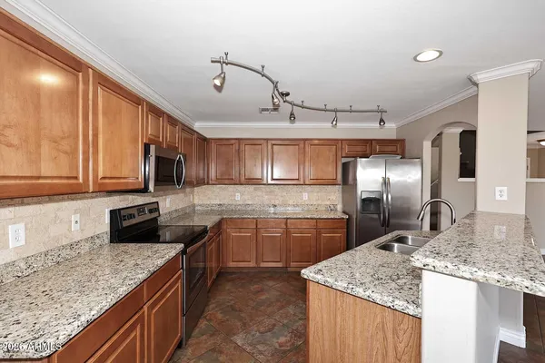 a kitchen with stainless steel appliances granite countertop a sink stove and refrigerator