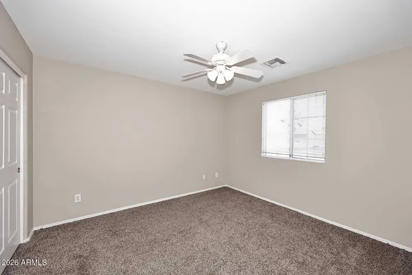 an empty room with a window and a fan