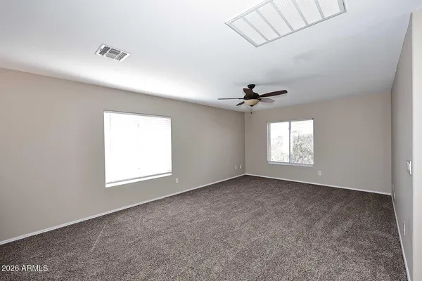 en empty room with windows and ceiling fan