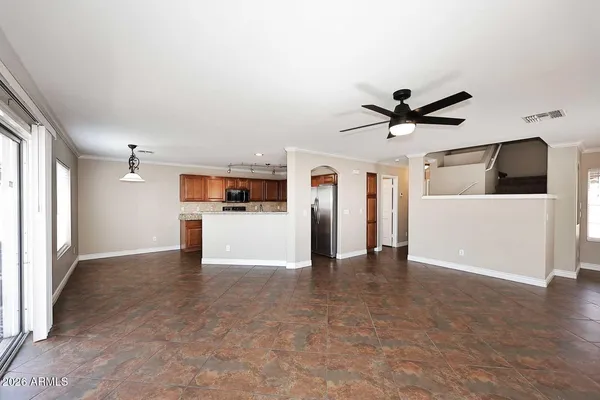 a view of a big room with wooden floor and a kitchen