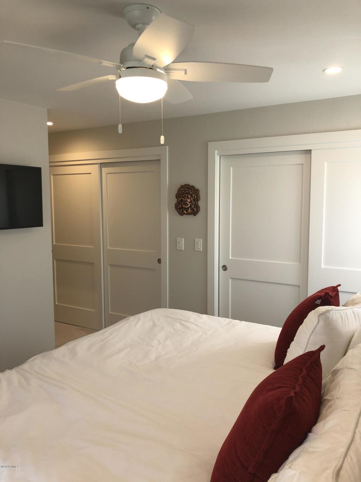 316 Wall Street, Unit 6 Eagle, CO 81631 - Photo 22 of 30 a bedroom with a bed and a chandelier